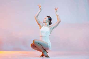 Dinamik dans solosu. Neon ışıkta sarı-turuncu arka planda dans eden kadın. Dans konsepti, dersler, okul