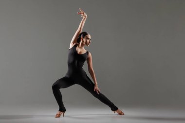 Dinamik dans solosu. Neon ışıkta sarı-turuncu arka planda dans eden kadın. Dans konsepti, dersler, okul