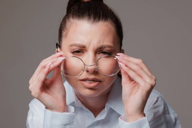 Gözlüklerini çıkardıktan sonra görme yetisi zayıf bir kadının yakın çekimi.