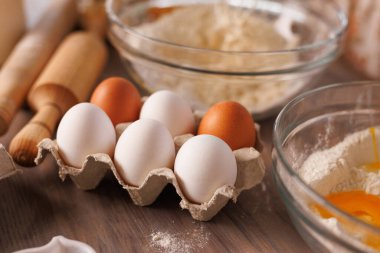 Kırsal mutfak tezgahında taze yumurtalar un ve oklavalarla hazırlanmış fırın malzemeleri..