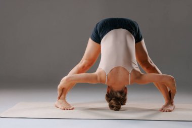Kadın geniş bacaklı yoga pozu veriyor. Esnekliği, dengeyi ve iç huzuru bir mindere yerleştiriyor..