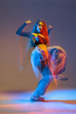 Canlı stüdyo ışıkları altında dans eden şık caz funk dansçısı. Parlak renkler ve kentsel dans enerjisiyle..