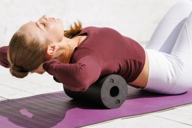 Kas iyileşmesi için köpüklü sırt masajı ve yoga minderinde esneklik. Sağlıklı bir yaşam tarzında rahatlık ve rahatlama..