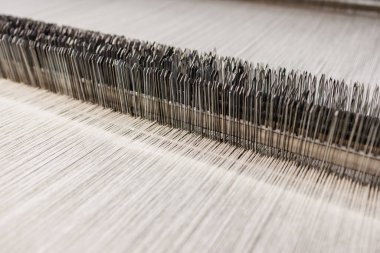 Modern bir endüstriyel tekstil fabrikasında kumaş dokuma tezgahının detaylı makro görüntüsü