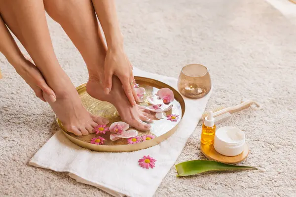 Çiçek banyosunda krem ve yağlı ayaklar, ev yapımı ayak bakımı su, yumuşaklık ve güzellik ayini.