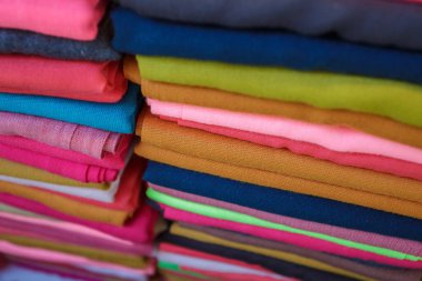 Tekstil pazarında renkli, geleneksel malzemeler ve dokuma dokuma dokularının sergilendiği canlı Türk kumaşı yığını