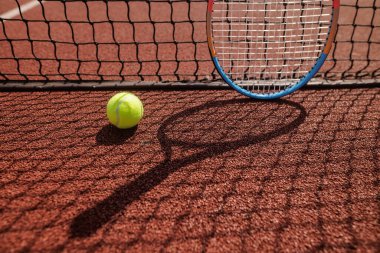 Kil kortunda tenis topu ve raket, rekabeti, hareketi ve aktif spor yaşam tarzını yakalamak