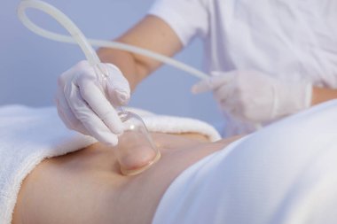 Profesyonel bir sağlık merkezinde deri sıkılaştırma, inceltme ve lenfatik drenaj için vakum masajı anti-selülit vücut tedavisi.