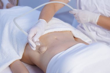 Modern bir kaplıca kliniğinde selülit önleyici vücut şekillendirme, inceltme ve lenfatik drenaj terapisi için vakum masajı..