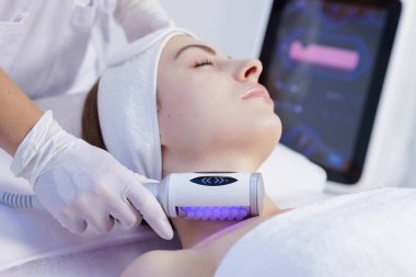 Modern bir kaplıca kliniğinde cilt sıkılaştırma, gençleştirme ve yaşlanmayı önleme amaçlı profesyonel yüz masajı.