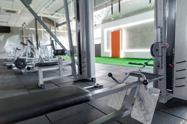 Geniş modern spor salonu. Güçlü eğitim ekipmanları ve sağlıklı yaşam tarzı için egzersiz makineleri var.