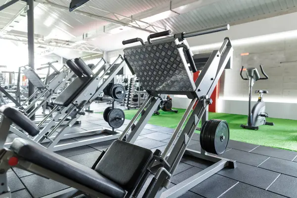 Bacak pres makinesi ve fitness, vücut geliştirme ve sağlıklı yaşam tarzı için güçlü eğitim ekipmanlarıyla modern spor salonu.
