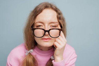 Yorgun gözlerle şaşı bakan bir kadın, kötü görüş ve göz yorgunluğu konsepti, optik sağlık