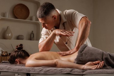 Erkek terapist, huzur ortamında sağlık, stres ve sağlık için rahatlatıcı sırt masajı sağlar..