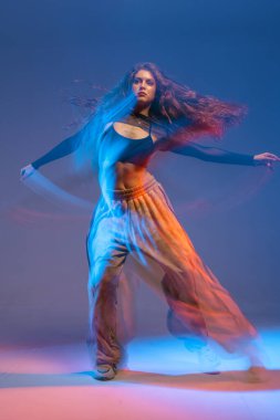 Kendine güvenen caz funk dansçısı renkli ışıklandırmasıyla modern dansın enerjisini ve tutumunu yakalıyor..