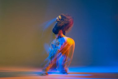 Modern tarzda etkileyici caz funk dansçısı canlı renkli ışıklar ve dinamik hareketlerle enerjik koreografi yapıyor..