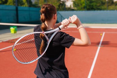 Servise hazır bayan tenis atletinin arka planı, eyleme, gençliğe ve açık havada spor motivasyonuna dikkat çekiyor