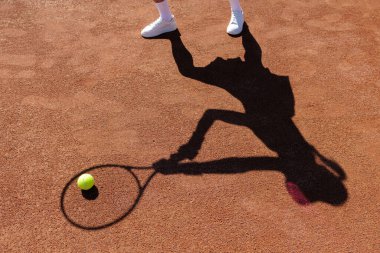 Kil üzerinde raket ve top taşıyan bir oyuncunun dinamik gölgesi kulüp antrenörlüğü ve turnuva yaratıcıları için ideal.