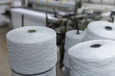 Large yarn spools in a textile workshop ready for weaving and spinning production showing industry machinery and quality manufacturing