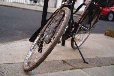 Kahverengi vintage tekerin yatay yakın plan fotoğrafı sokağa park edilmiş bisiklete benziyor. Kentsel sürdürülebilir ulaşım. Sıfır karbon emisyonu.