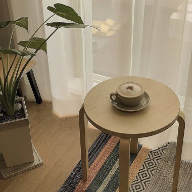 İçinde sehpa ve sandalye olan modern oturma odasının içinde.