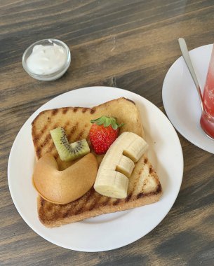 Beyaz tabakta kremalı lezzetli taze çilekler.