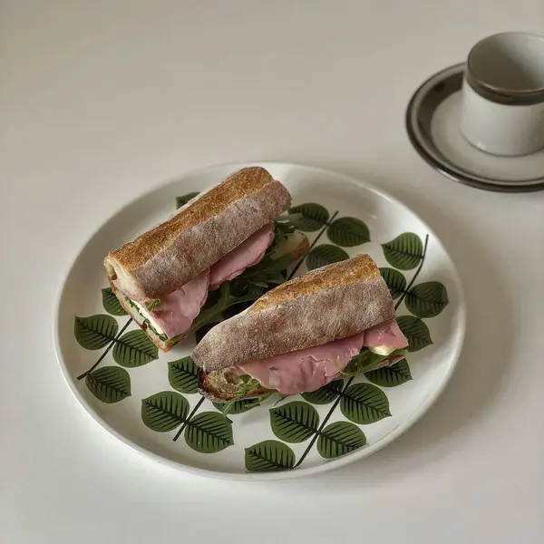 Sosisli sandviç ve beyaz tabakta salata.