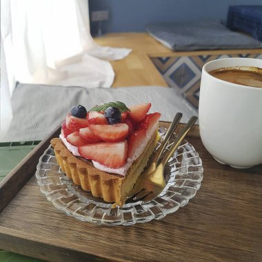 Taze çilekli turta ve bir fincan kahve.