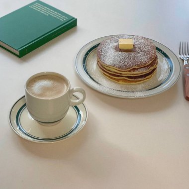 Bir fincan kahve ve beyaz bir masada kek.