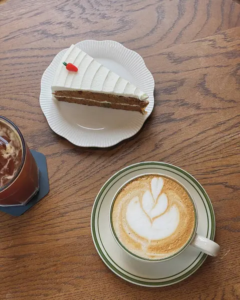 Lezzetli bir çikolatalı kekle beyaz bir masada sıcak bir kahvenin dikey görüntüsü.