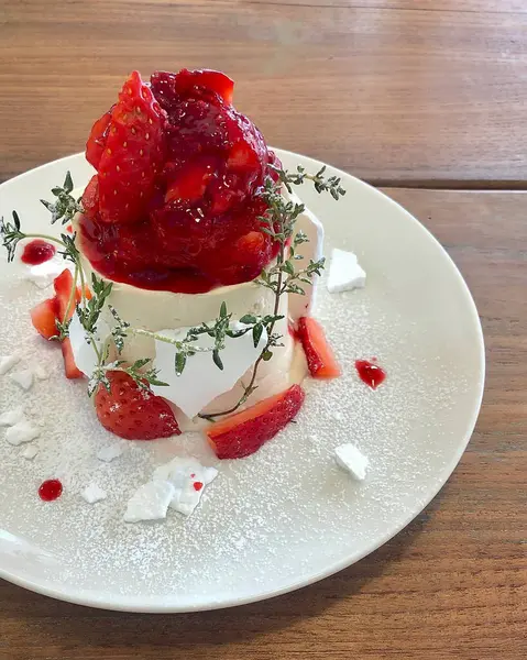 Nane ve dondurmalı beyaz bir tabakta lezzetli çilekli pasta.