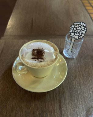 Kahve fincanı ve kapuçino masada.