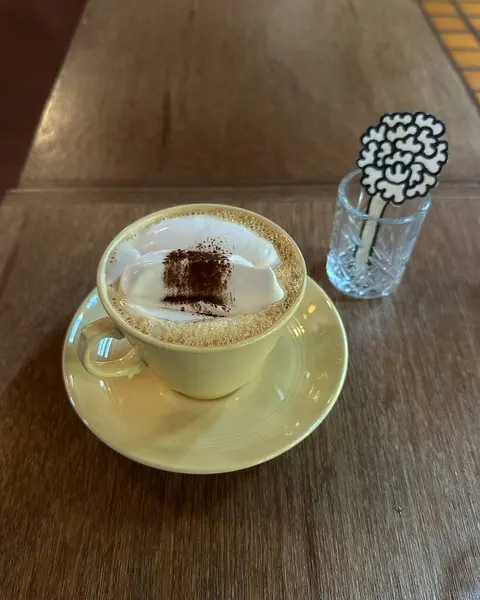 Kahve fincanı ve kapuçino masada.