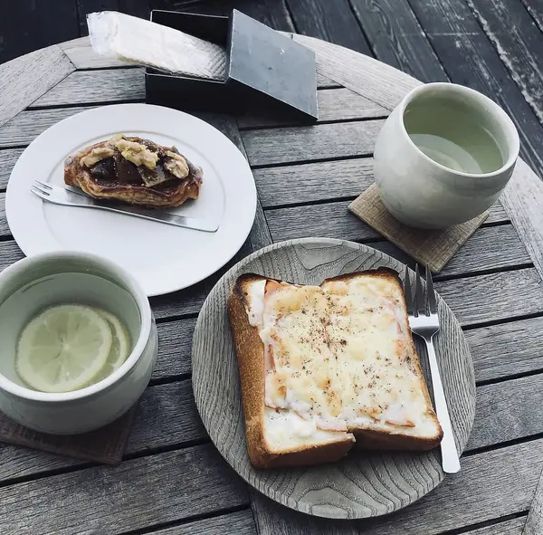 Bir fincan kahve ve sandviçin yakın plan çekimi.