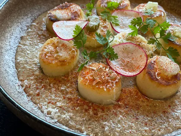 Kızarmış deniz taraklarını otlarla kaplayın.