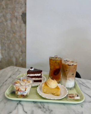 Bir bardak buzlu çay, yanında pasta ve pasta.