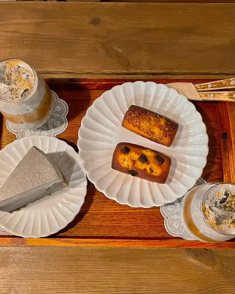 Bir fincan kahve ve bir bardak sütlü lezzetli bir pastanın yakın çekimi.