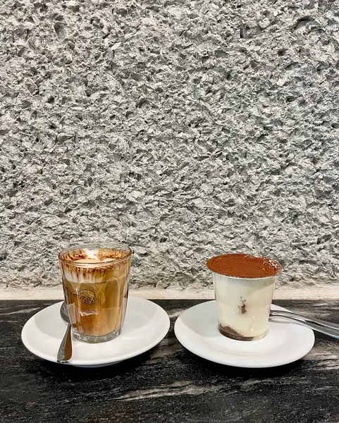 Bir fincan espresso ve iki fincan çikolatalı kahve. Mermer arka planda iki fincan kahve..
