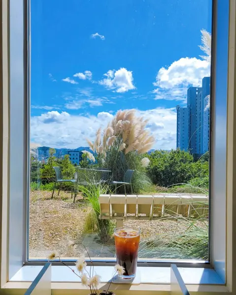 Kahve fincanı, çiçekler ve masada bir bardak çay.