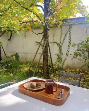 Masanın üzerinde bir fincan kahve, yanında bir kitap ve bir fincan çay..