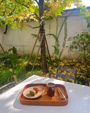 Bir fincan çay ve ahşap masada bir pasta.