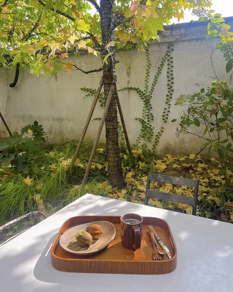 Bir fincan çay ve ahşap masada bir pasta.