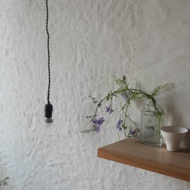 Çiçekli vazo ve masada mum.