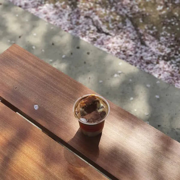 Masanın üzerinde kaşıkla bir fincan çay.