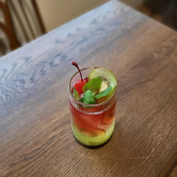 Tahta bir masada buzlu ve naneli taze çilekli smoothie.