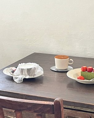 Bir tabak meyveli bir masa ve bir fincan kahve.