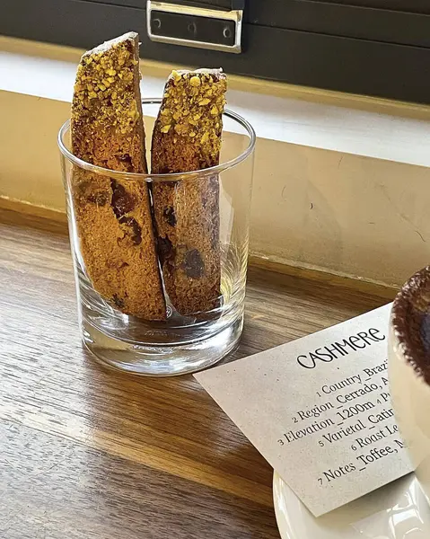 Lezzetli bir kekin dikey çekimi ve masada bir fincan kahve.