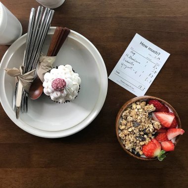 Bir fincan kahve ve tahta bir masada kaşıkla kasede dondurma.