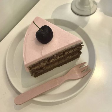 Beyaz arka planda beyaz bir fincan çayla çikolatalı pasta.