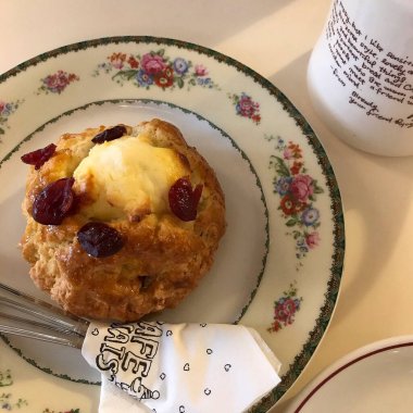 Tahta tabakta beyaz bir pastayla bir fincan çay.